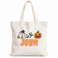 An off-white canvas tote bag with a Halloween graphic featuring a ghost, a pumpkin, bats, and the name 'JOHN' in orange, shown on a plain white background.